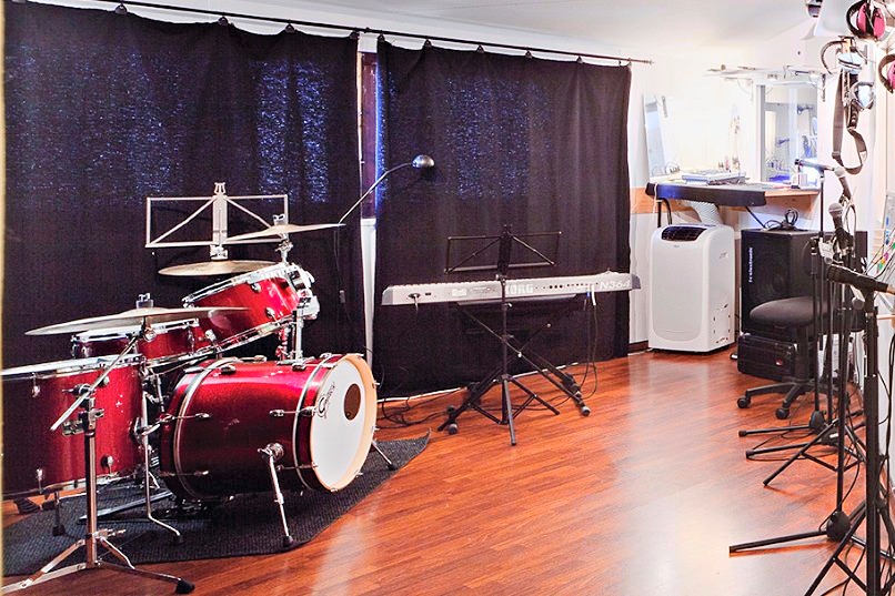 Übungsraum im Studio: Schlagzeug, Keyboard und Mikrofone bereit
