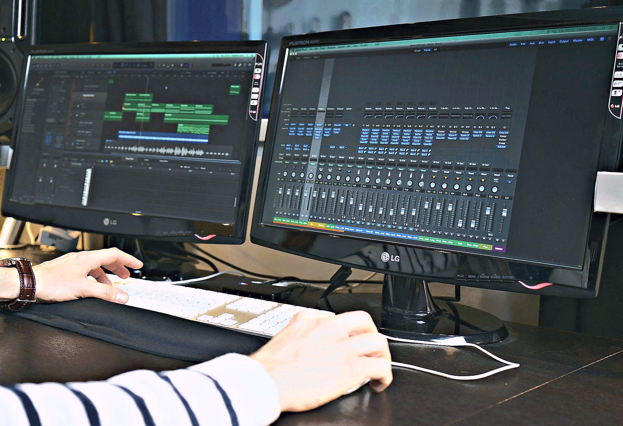 Logic Pro auf zwei Bildschirmen, Hände an Tastatur und Maus